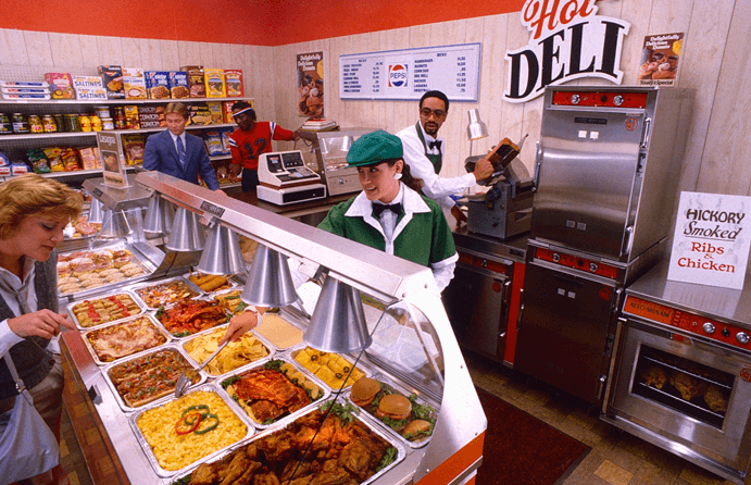 1980s retail worker serving food out of a merchandising display case