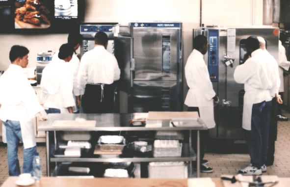 A group of chef trainees in an industrial kitchen