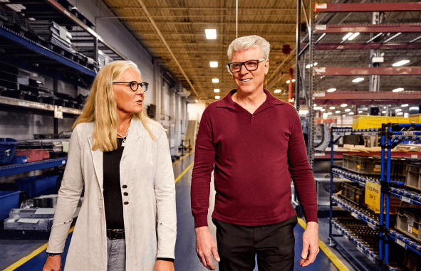 Steve Maahs and Karen Hansen walking side by side on the shop floor